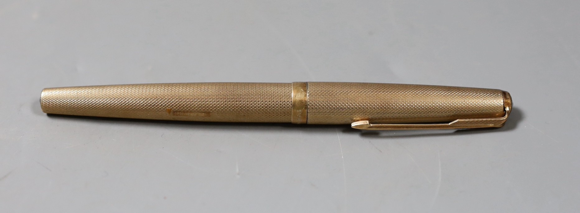 A 1970's engine turned 9ct gold cased Parker fountain pen. 13cm long